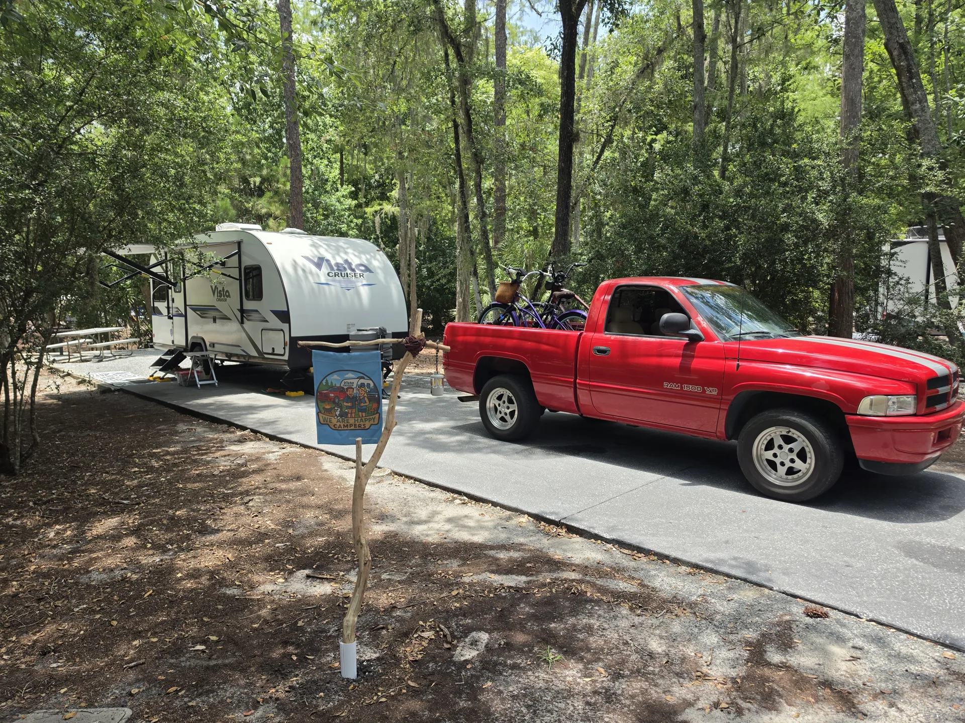 Our red Dodge Ram SS/T and Vista Cruiser tucked into a wooded campsite